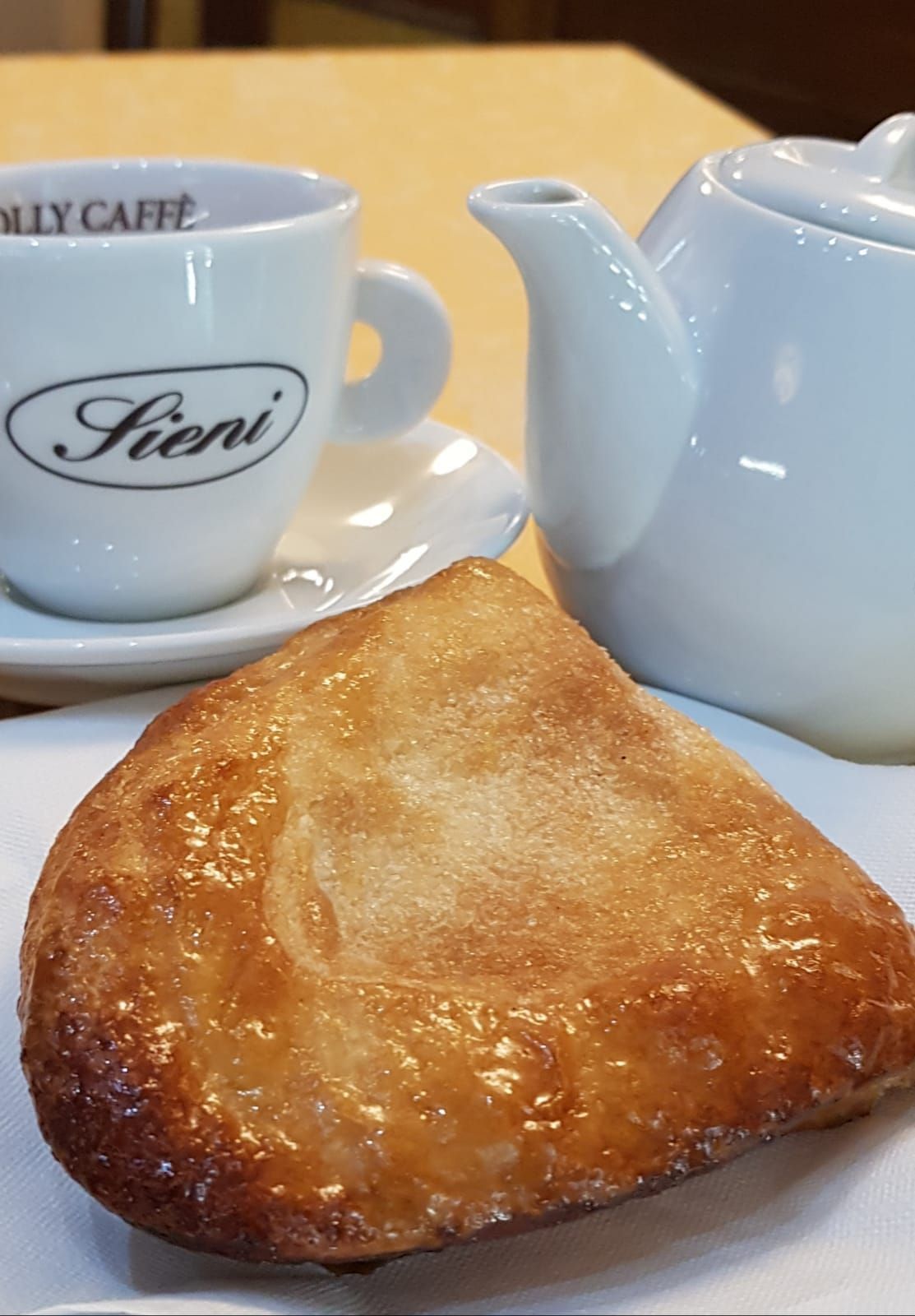 Un croissant e una tazza di caffè su un tovagliolo su un tavolo.