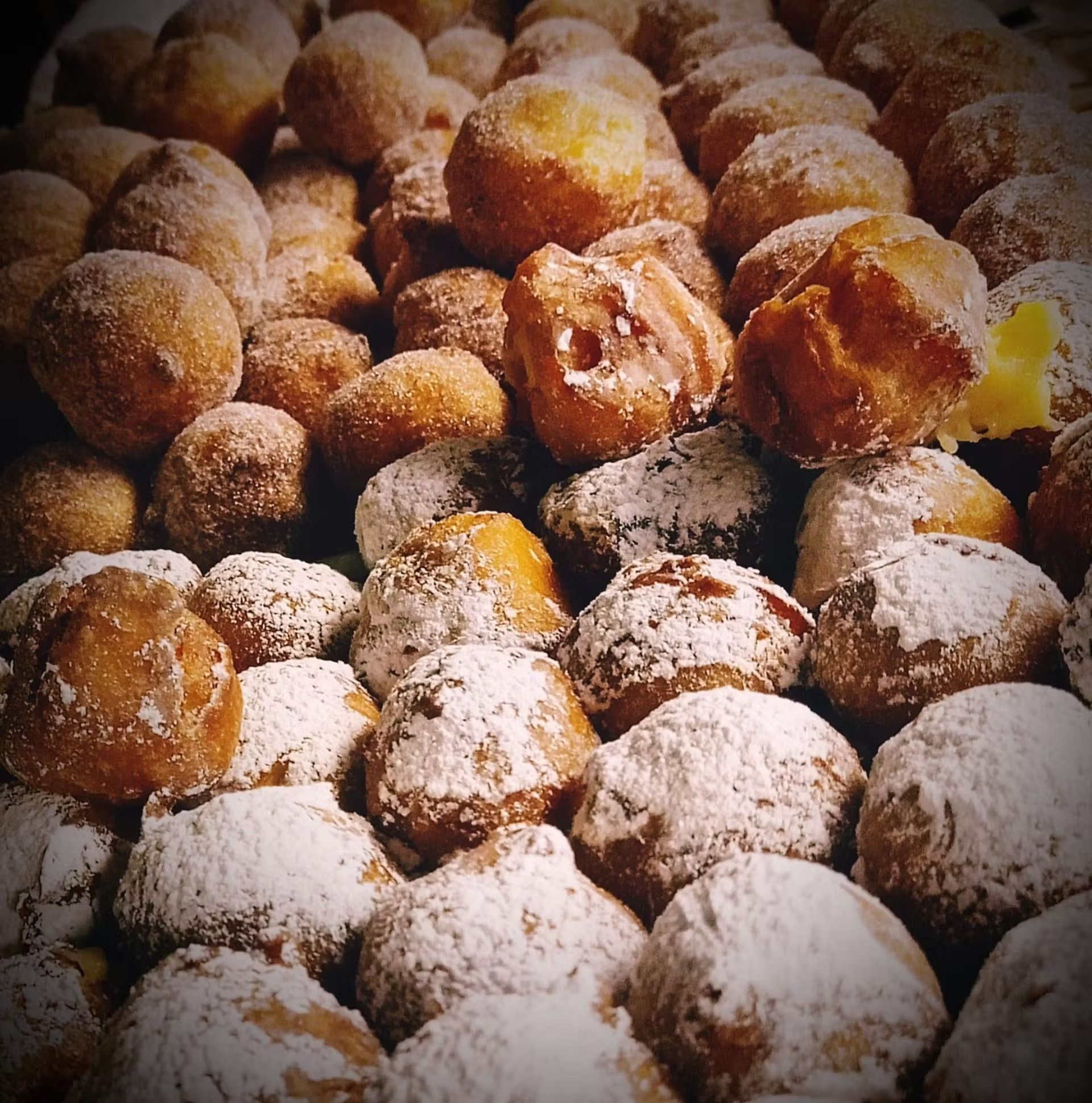Una pila di ciambelle ricoperte di zucchero a velo
