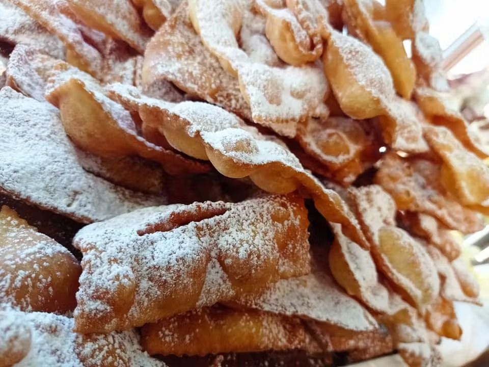 Una pila di cibo fritto con zucchero a velo sopra