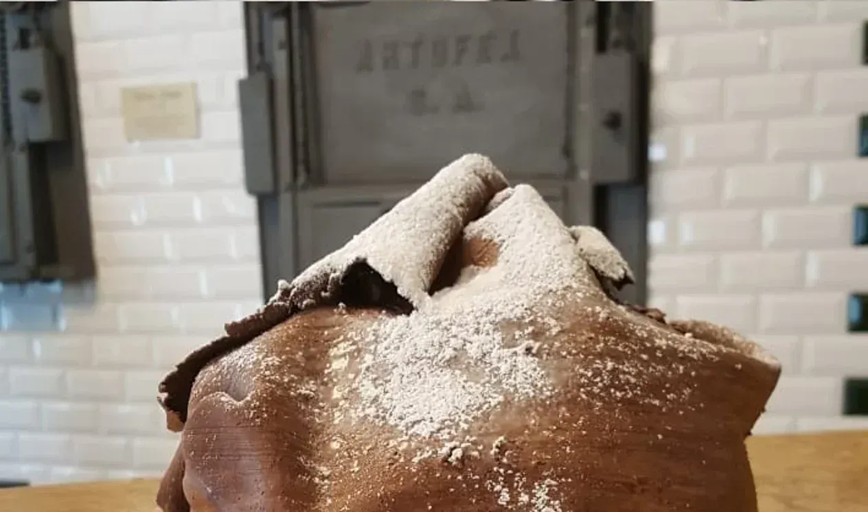 Una fetta di torta al cioccolato ricoperta di zucchero a velo su un tavolo.