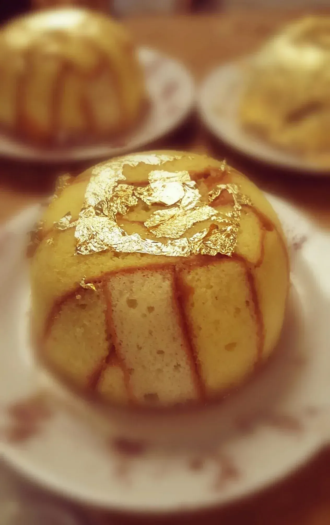Una torta con foglia d'oro sopra è su un piatto bianco