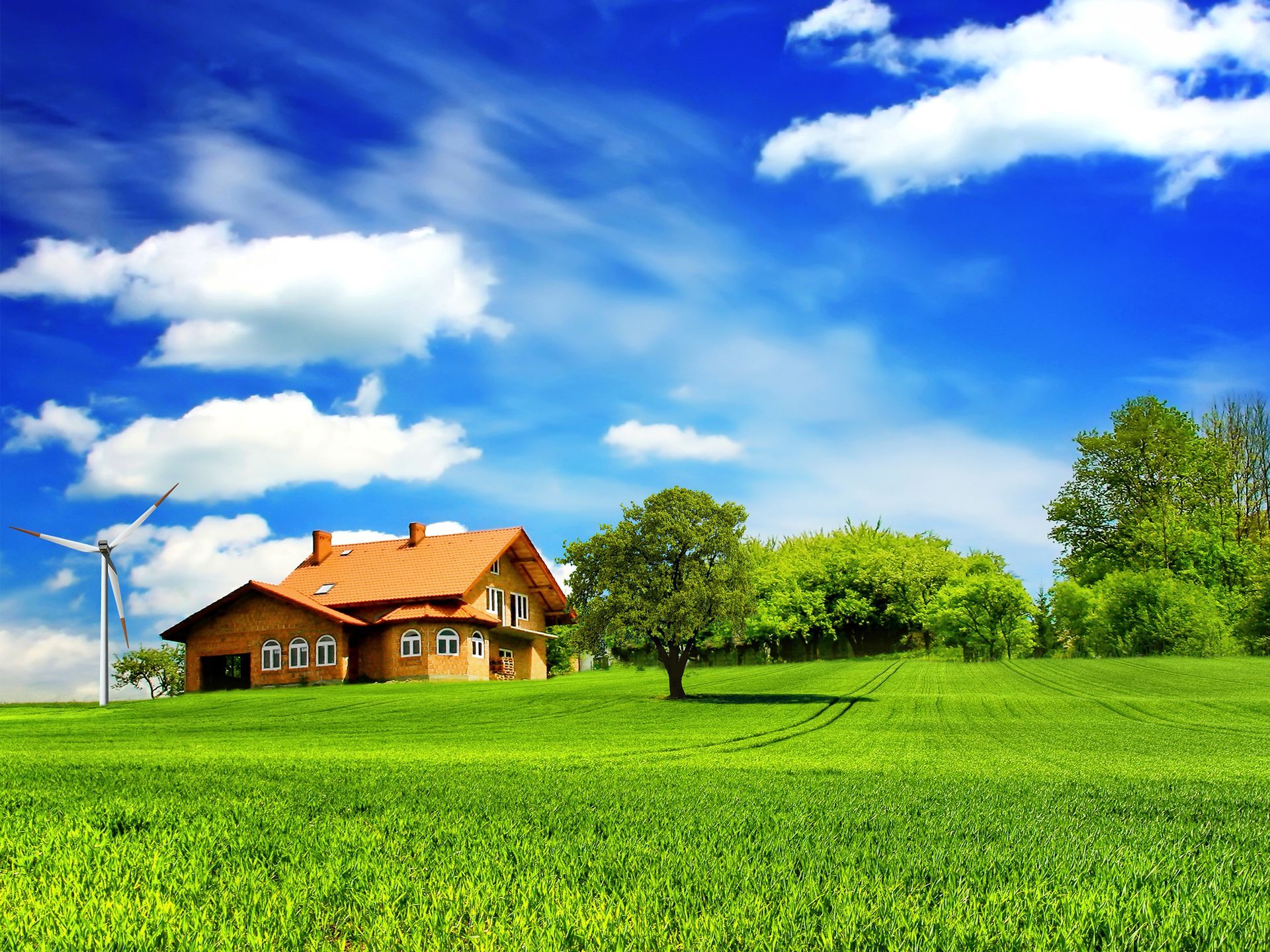 A house in the middle of a green field with a windmill in the background