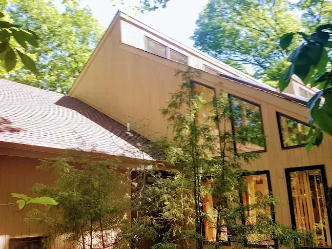 A house with a lot of windows and trees in front of it