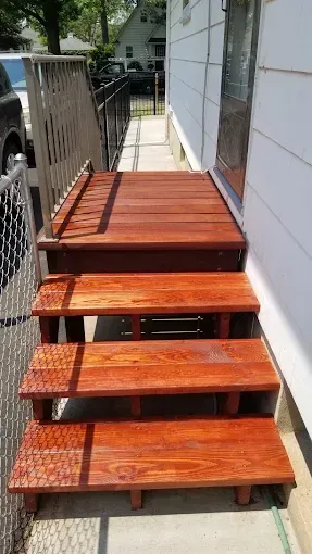 A set of wooden stairs leading up to a house.