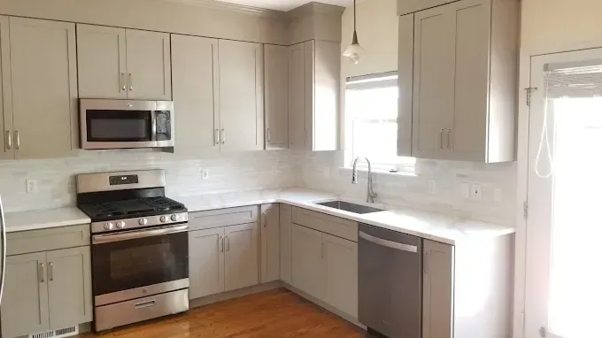A kitchen with stainless steel appliances and white cabinets.