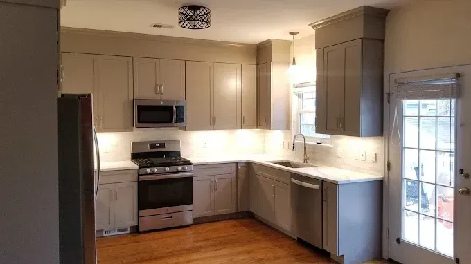 A kitchen with stainless steel appliances and white cabinets.