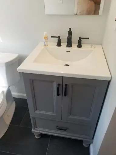A bathroom with a sink , toilet and mirror.