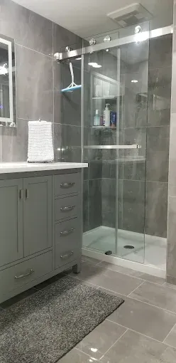 A bathroom with a sliding glass shower door and a sink.