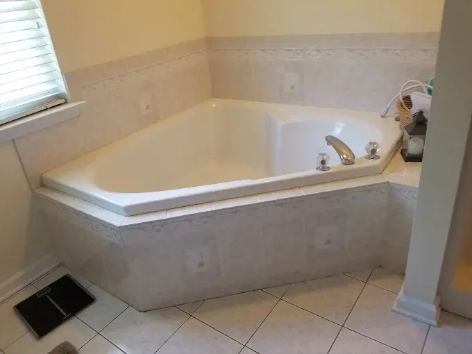 A bathtub is sitting in a bathroom next to a window.