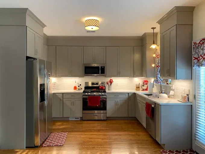 A kitchen with gray cabinets and stainless steel appliances
