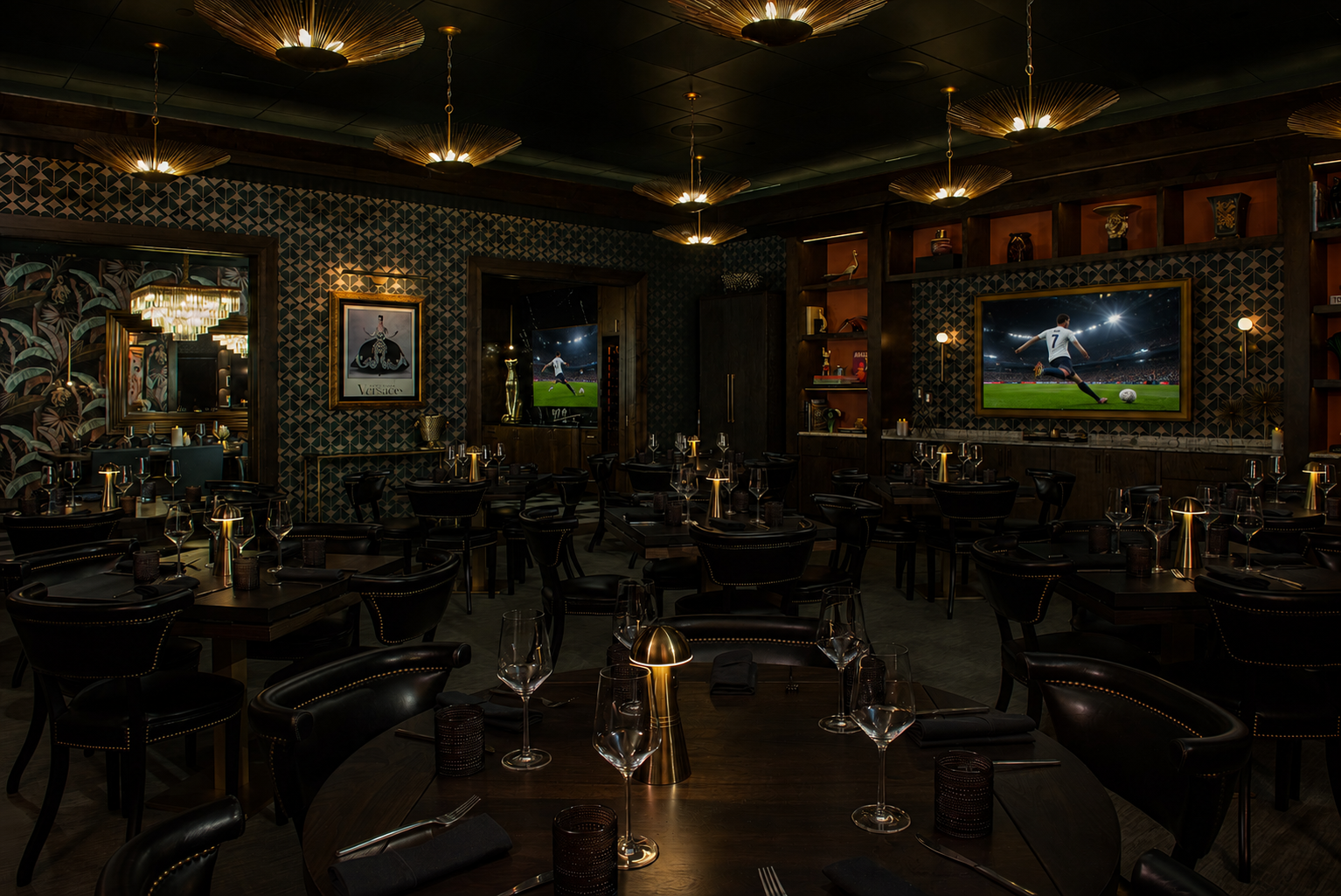 Dim upscale bar or lounge with dark decor, mirrors, chandeliers, and TVs showing a sports game.