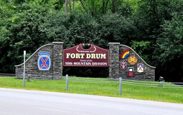 A sign for Fort Drum sitting on the side of a road.