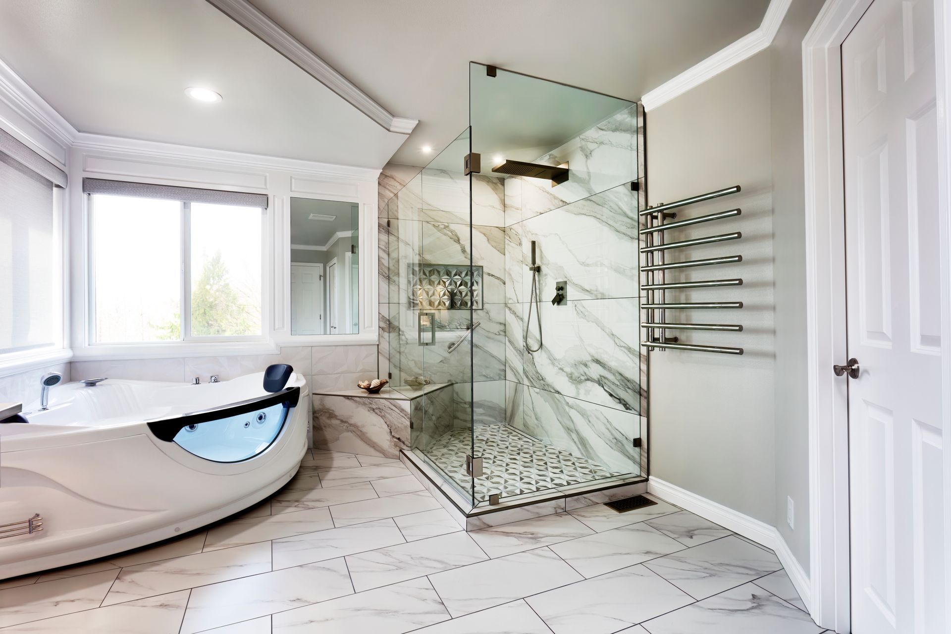 Modern bathroom with freestanding tub, glass shower, and white marble tile floor