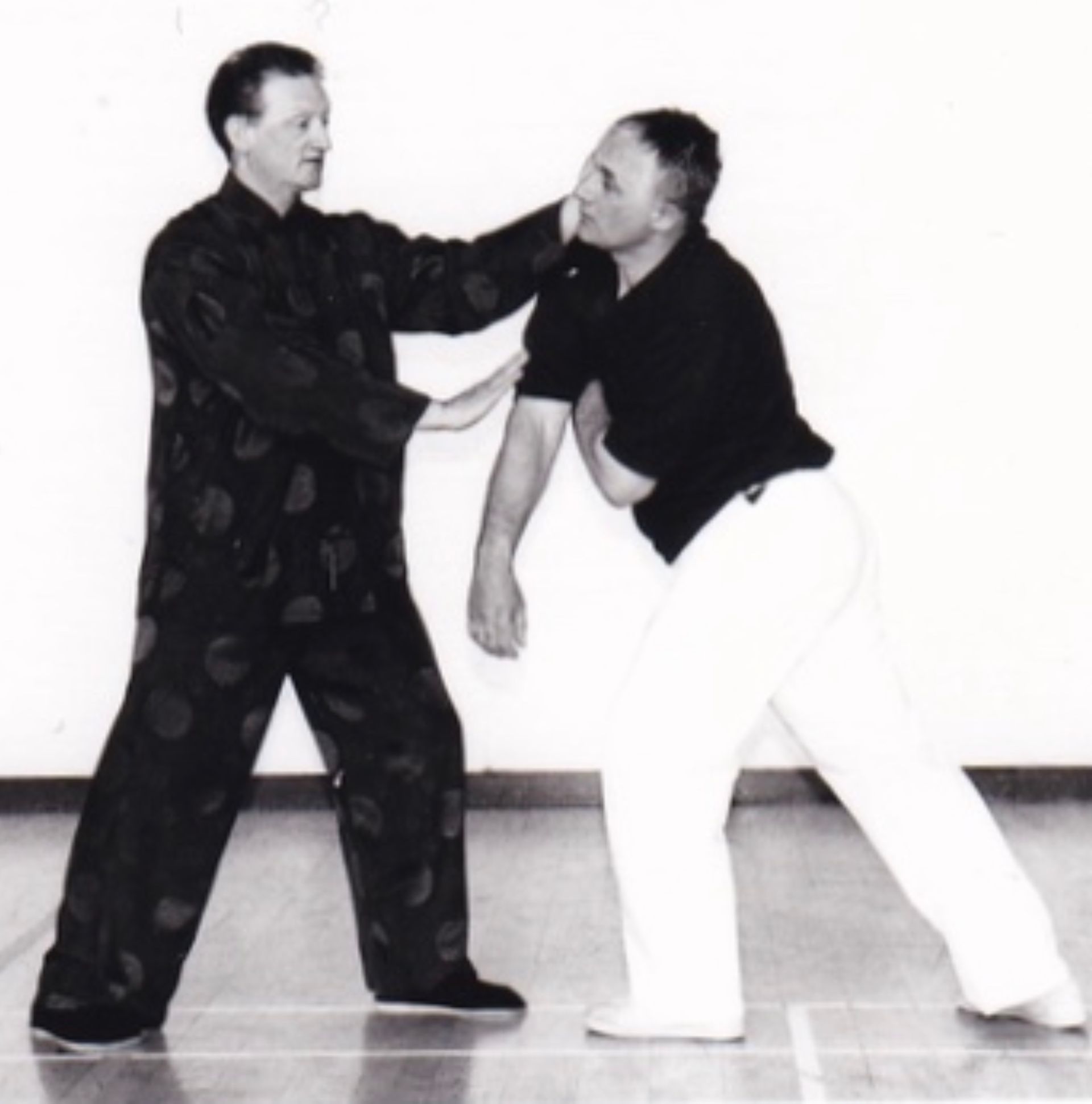 A black and white photo of two men practicing martial arts Five Winds Tai Chi Chuan 