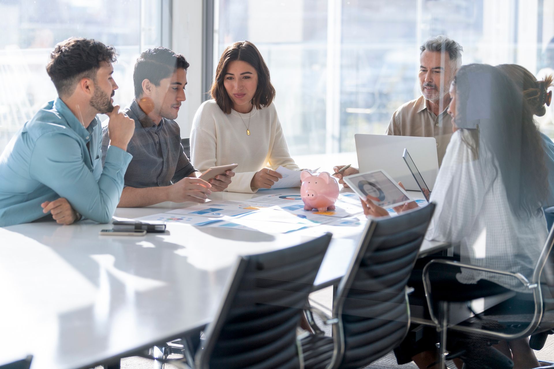 A group of people are sitting around a table in a conference room having a meeting.