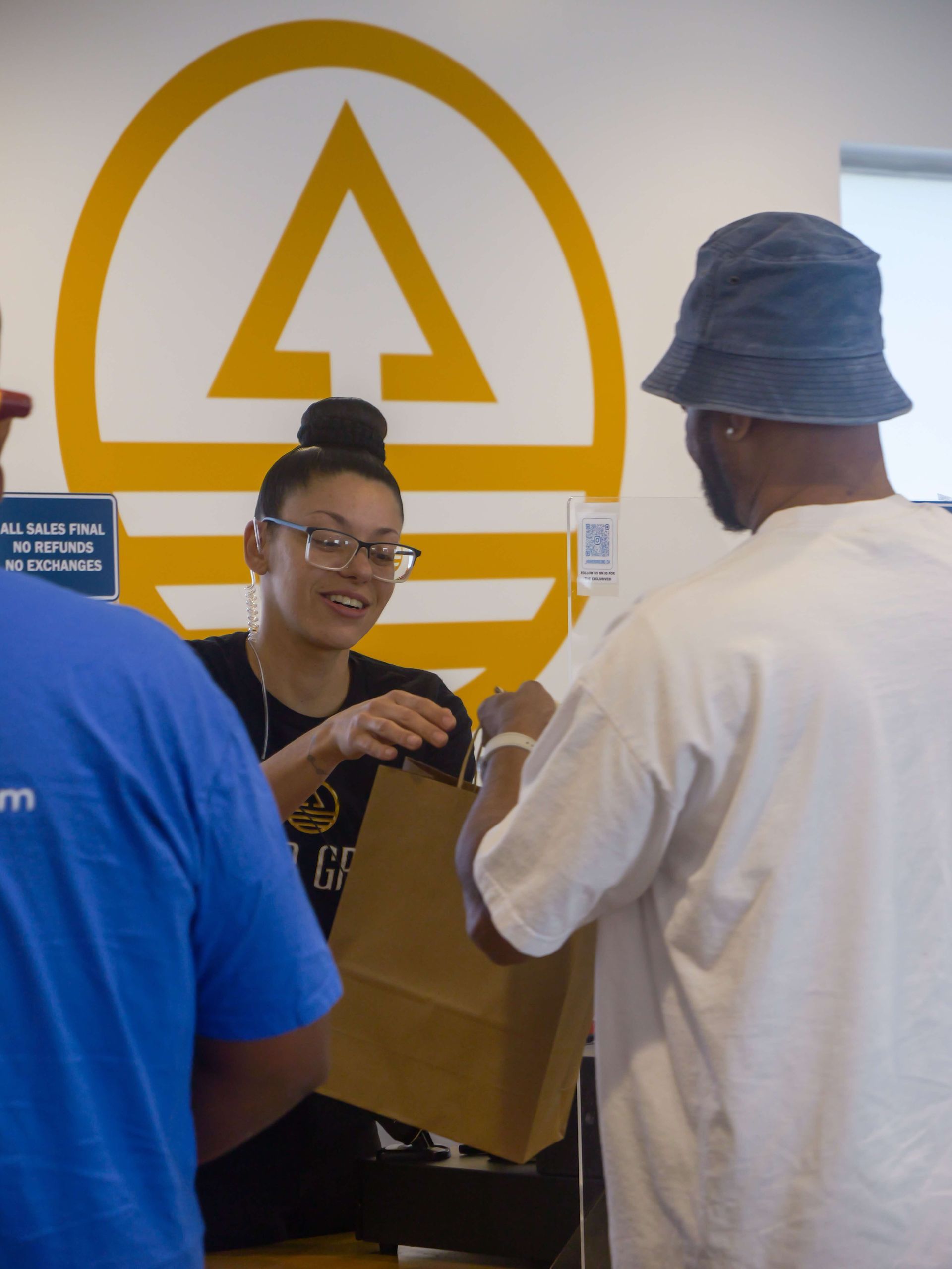 a woman is holding a bottle of liquid cannabis in a store .
