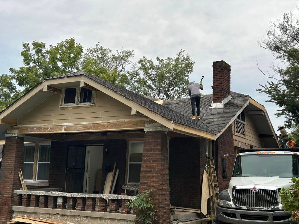 A man is standing on the roof of a house.