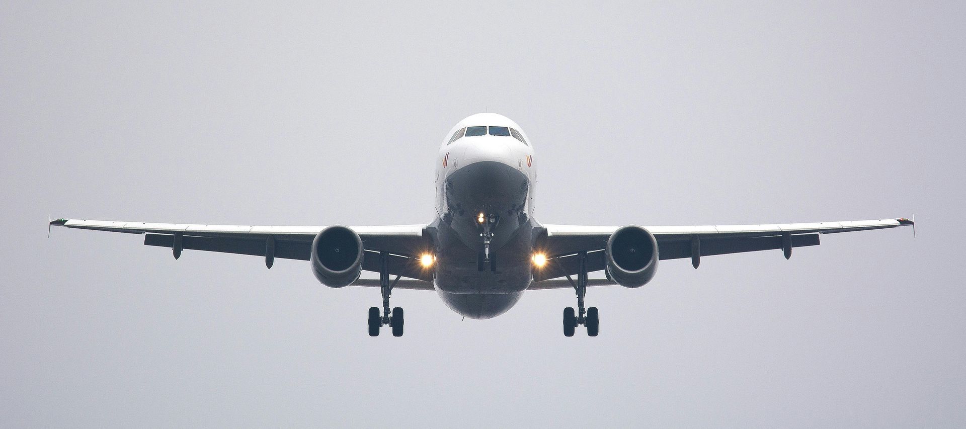 A large passenger jet is flying through a cloudy sky.