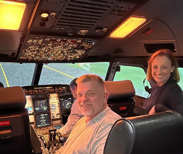 A man and a woman are sitting in the cockpit of an airplane