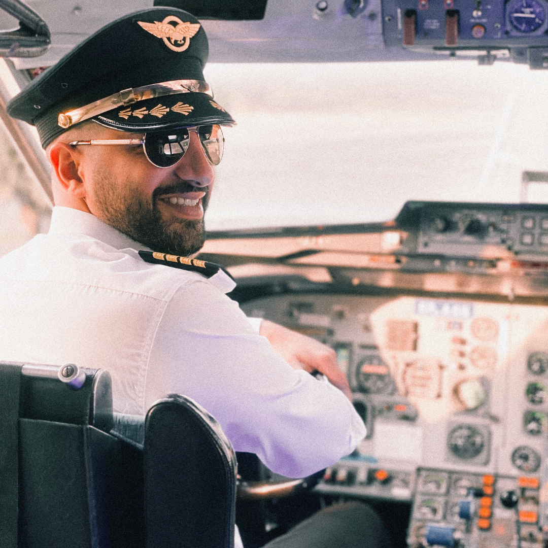 A man in a suit and tie is standing in front of an airplane