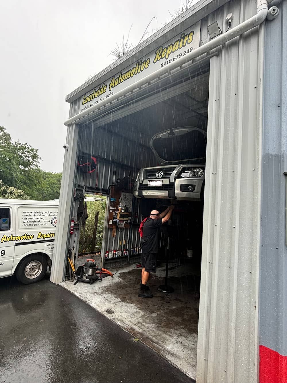 A Man Is Working On A Car In A Garage — Coastwide Automotive Repairs In Nambour, QLD