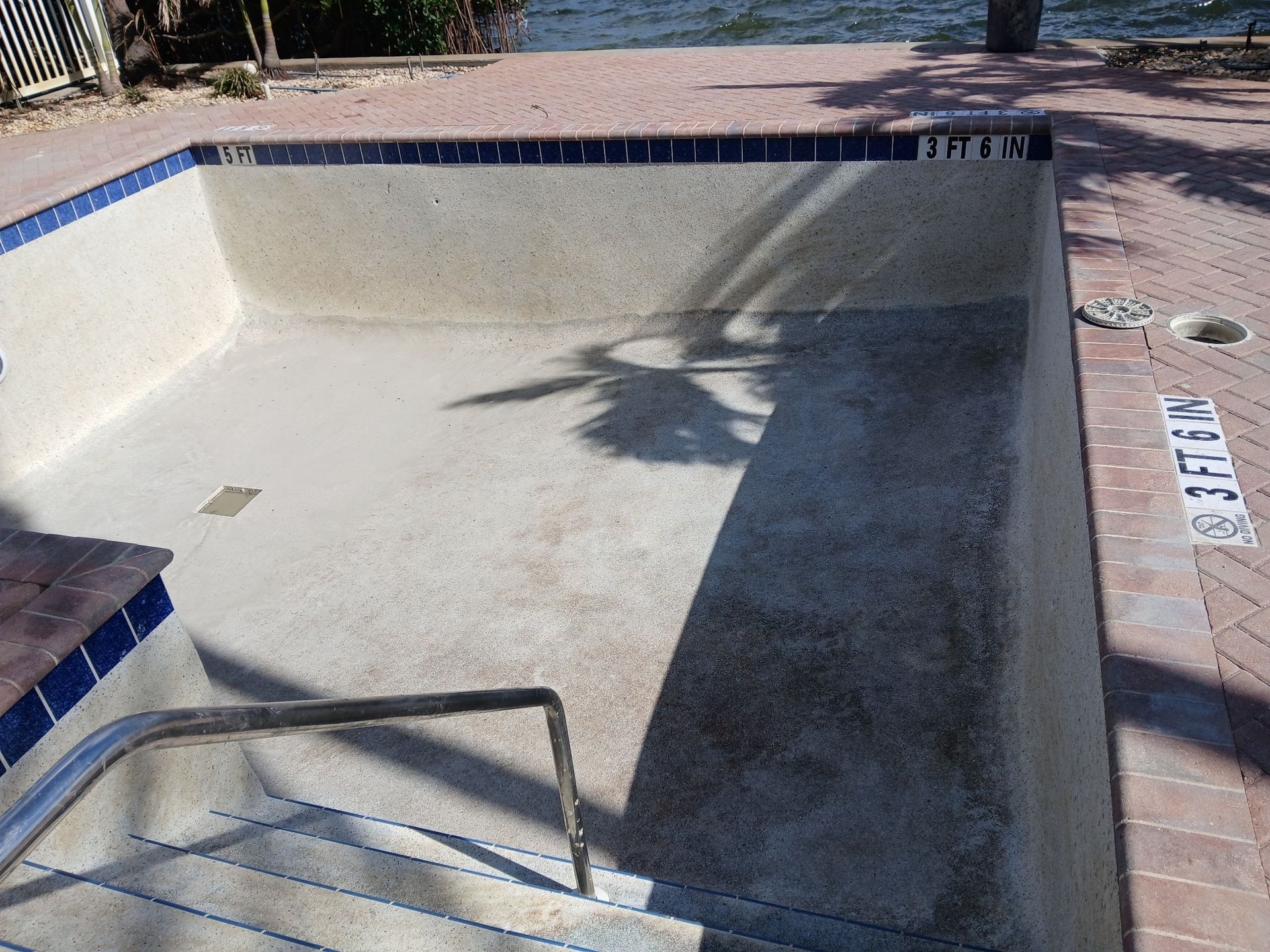 An empty swimming pool with stairs leading to it