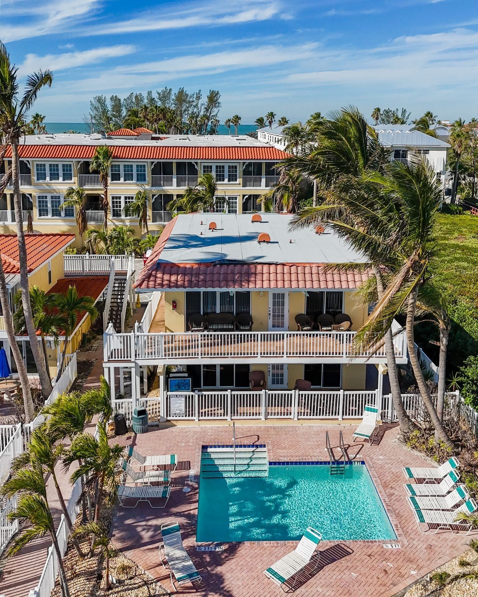 An aerial view of a house with a large swimming pool in front of it