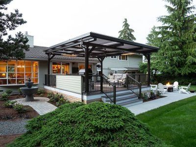 A house with a covered patio with chairs and a fire pit