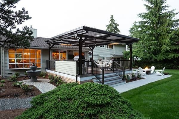 The backyard of a house with a pergola and a fire pit