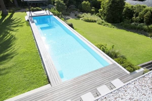 A large swimming pool surrounded by grass and trees