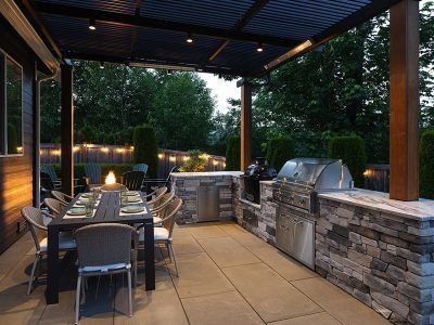 A patio with a table and chairs and a grill