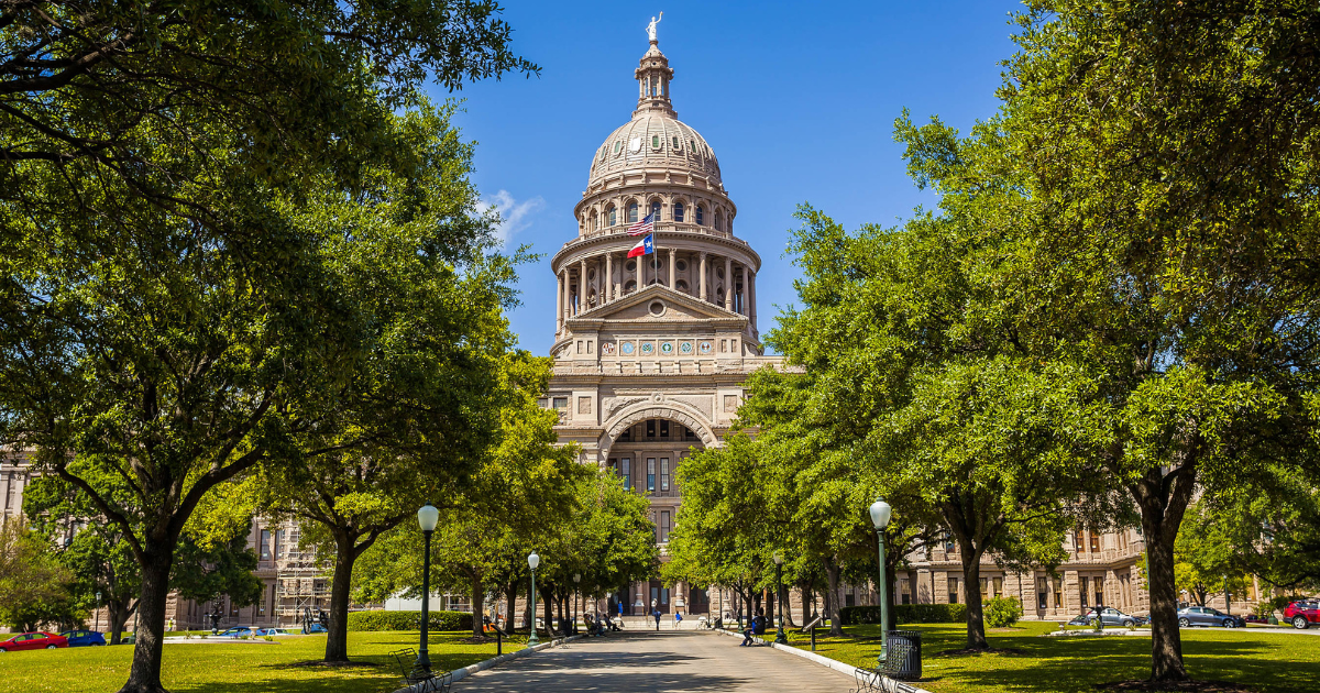 A living room with a couch , chairs , coffee table , fireplace and television.