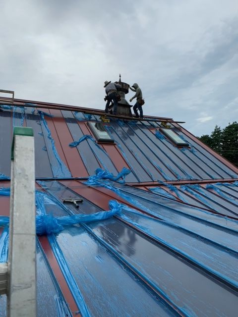 Two men are working on the roof of a building.