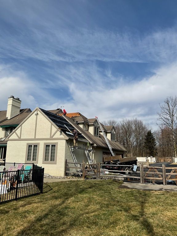 A man is standing on the roof of a house.