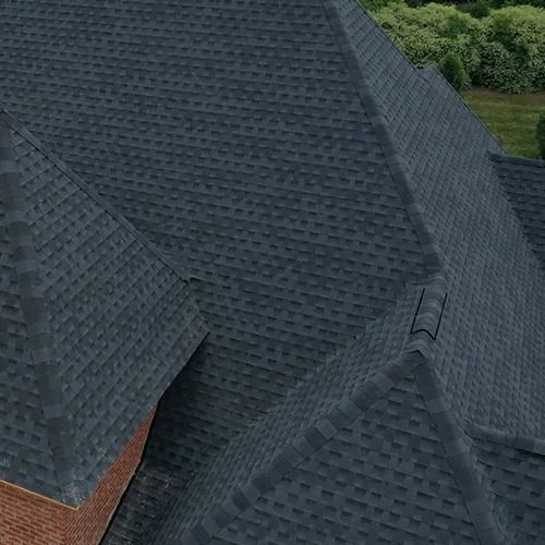 An aerial view of a black roof on a brick house.