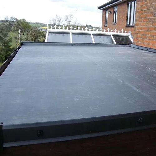 A black roof is sitting on top of a brick building.