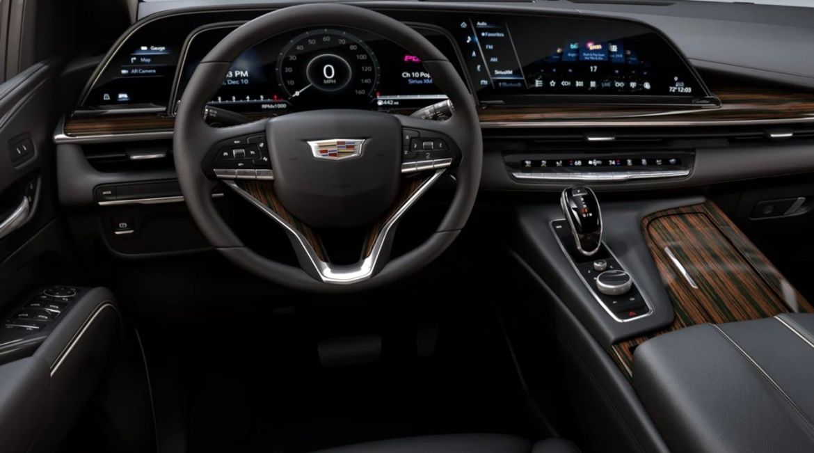 The interior of a cadillac escalade with a steering wheel and dashboard.