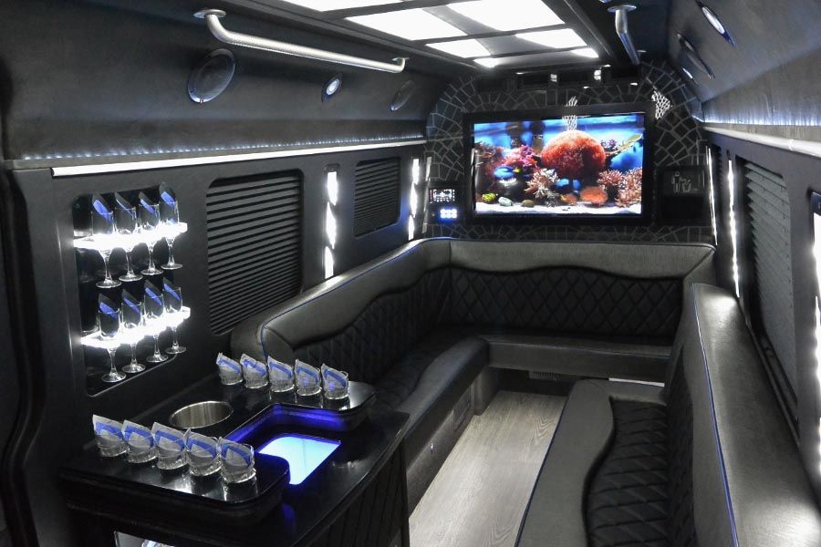 The inside of a limousine with a couch and a television