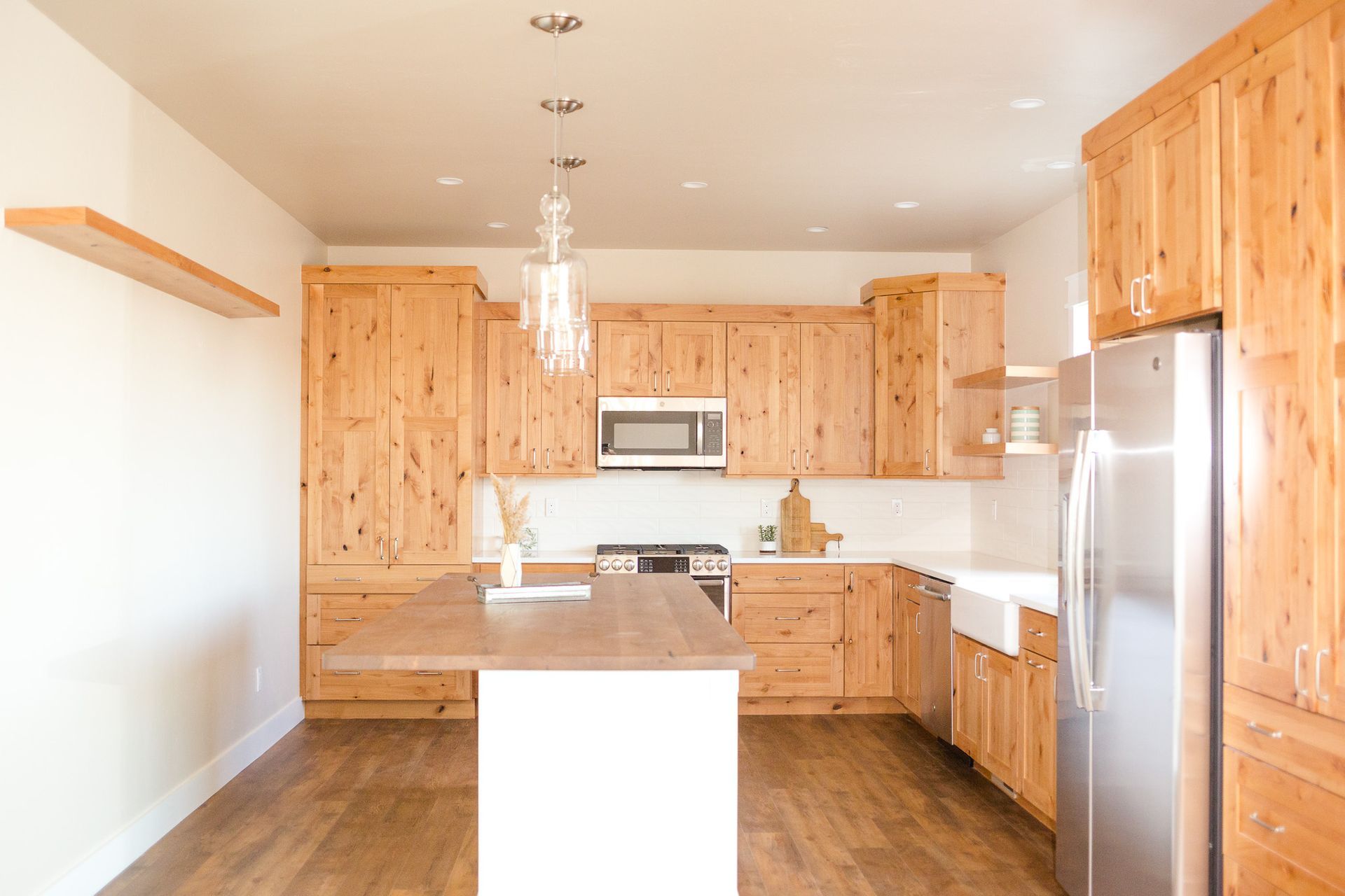 Kitchen with light wood cabinets, stainless steel refrigerator, and central island.