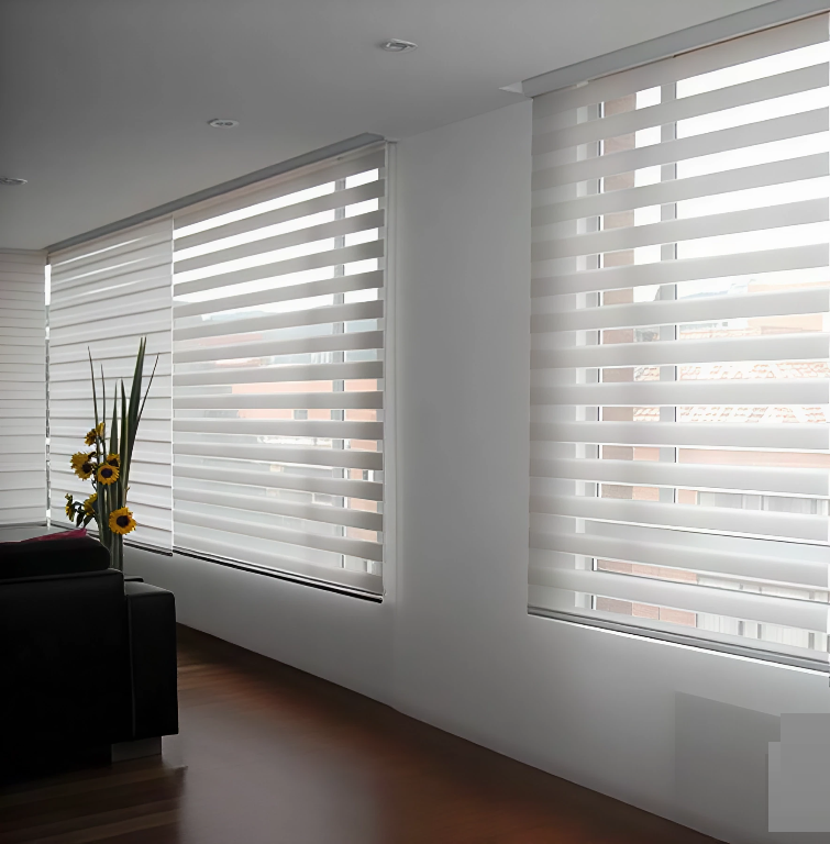 Persianas horizontales blancas que cubren una ventana y ocultan parcialmente la vista exterior.