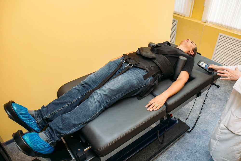 a woman is laying on a bed getting a chiropractic care.
