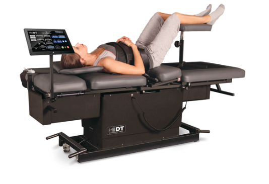 a woman is laying on a bed getting a chiropractic care.