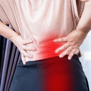 a woman is holding her back with sciatica pain .