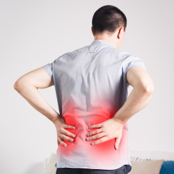 a man is holding his back with sciatica pain.
