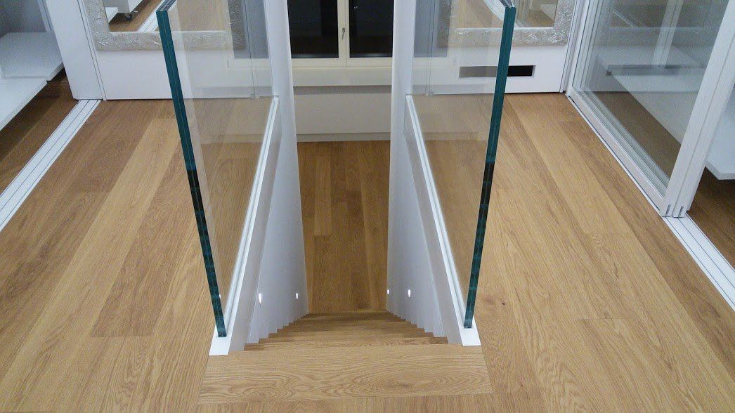 parquet su scale dall'alto con corrimano in vetro