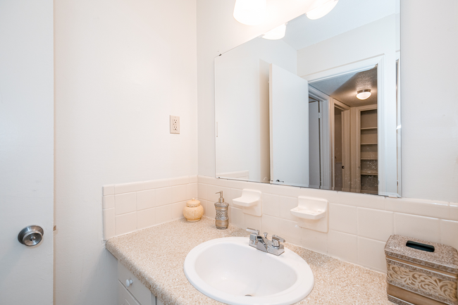 A bathroom with a sink and a mirror.