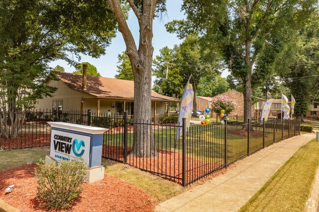 A house with a fence around it and a sign in front of it.