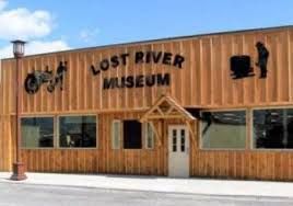 The Lost River Museum building features vertical wooden siding, large front windows, and silhouettes of farm equipment.