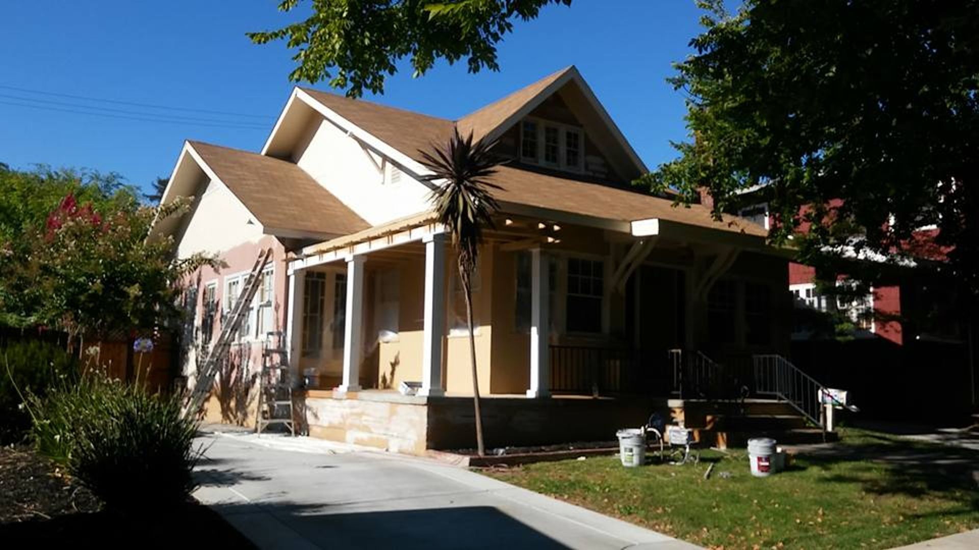 A house is being painted on a sunny day