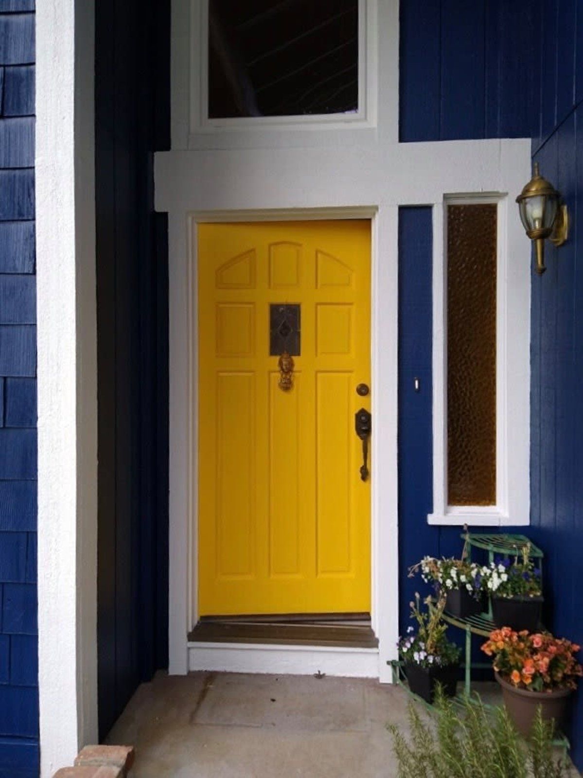 A yellow door on a blue and white house